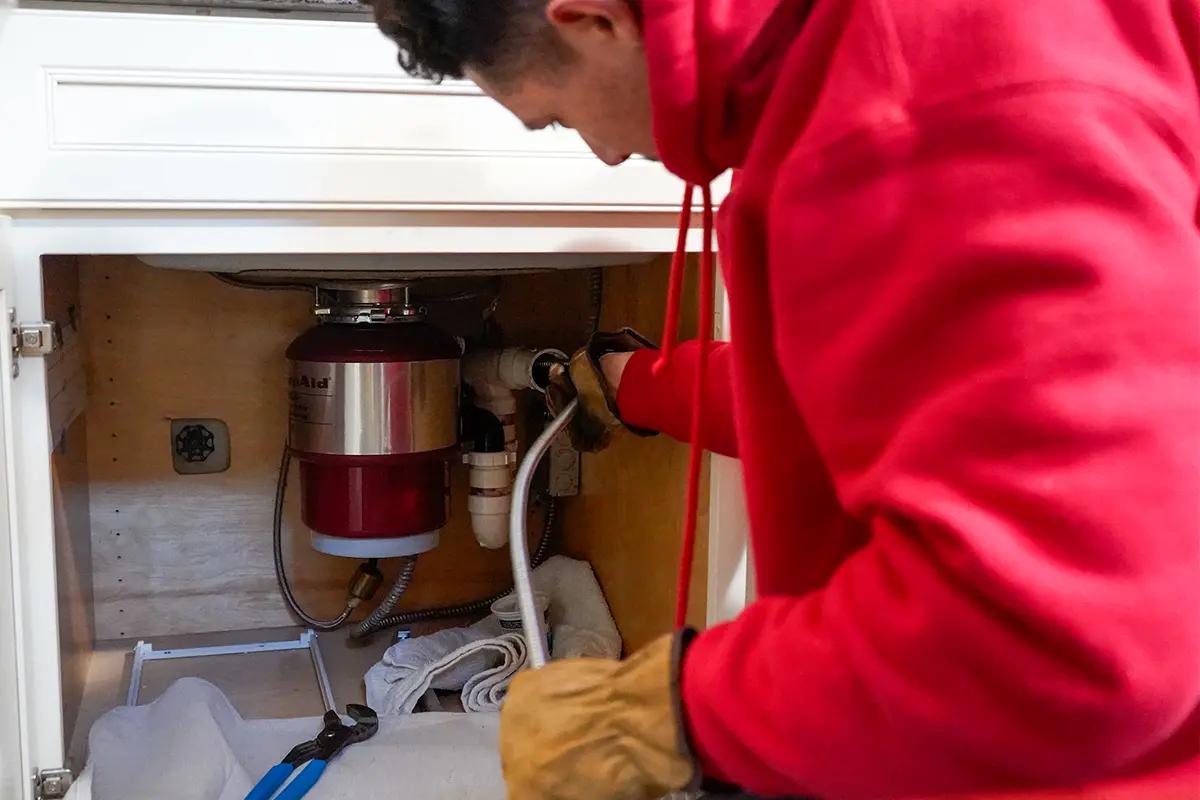 J. Blanton plumber working on the drain under a kitchen sink