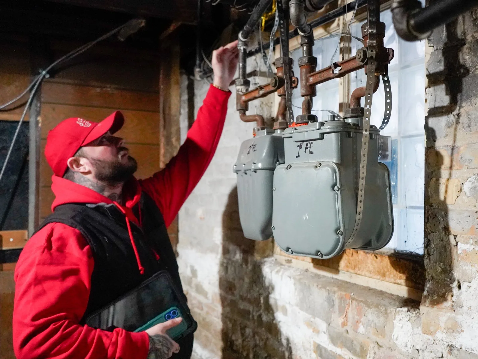 J. Blanton plumber inspecting the gas meters and gas line connections in a basement