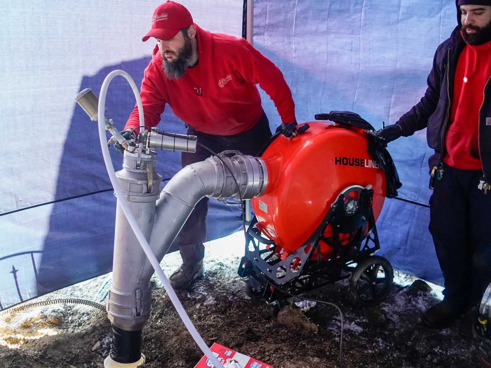 J. Blanton plumbers working a sewer lining machine connected to the cleanout at a residential sewer repair