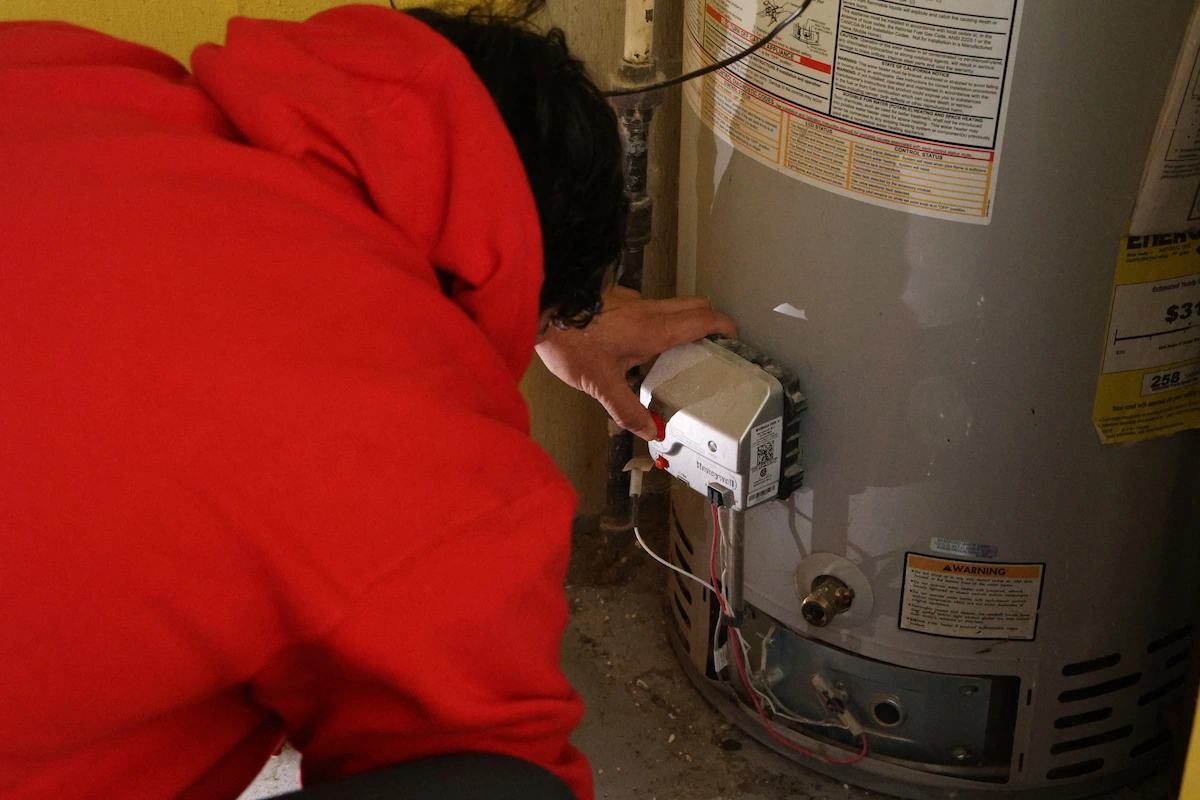 J. Blanton Plumbing technician checking the gas control valve on a tank water heater