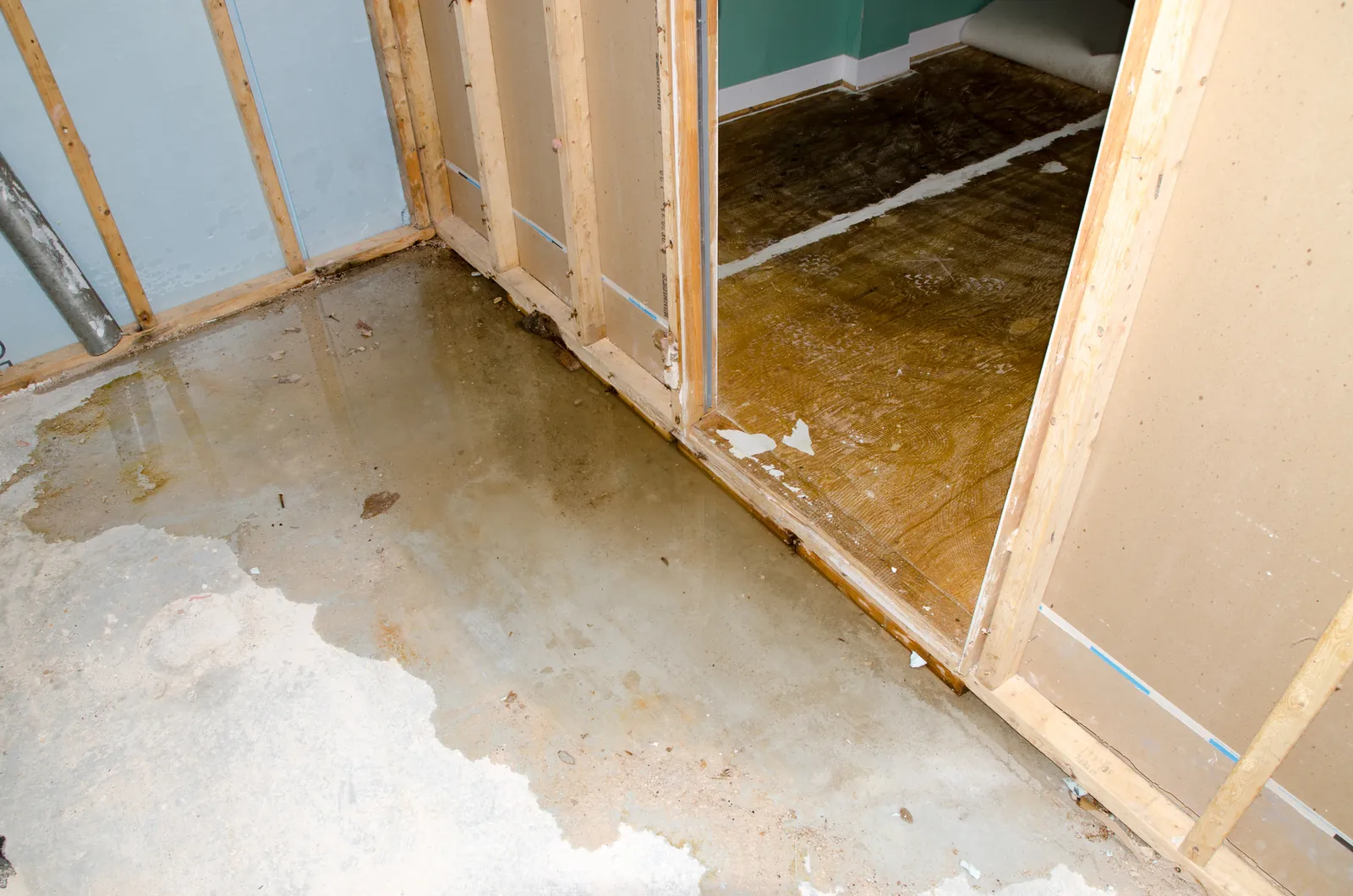 Water-stained basement floor and opened drywall after a sewer backup, a common warning sign of a sewer line problem