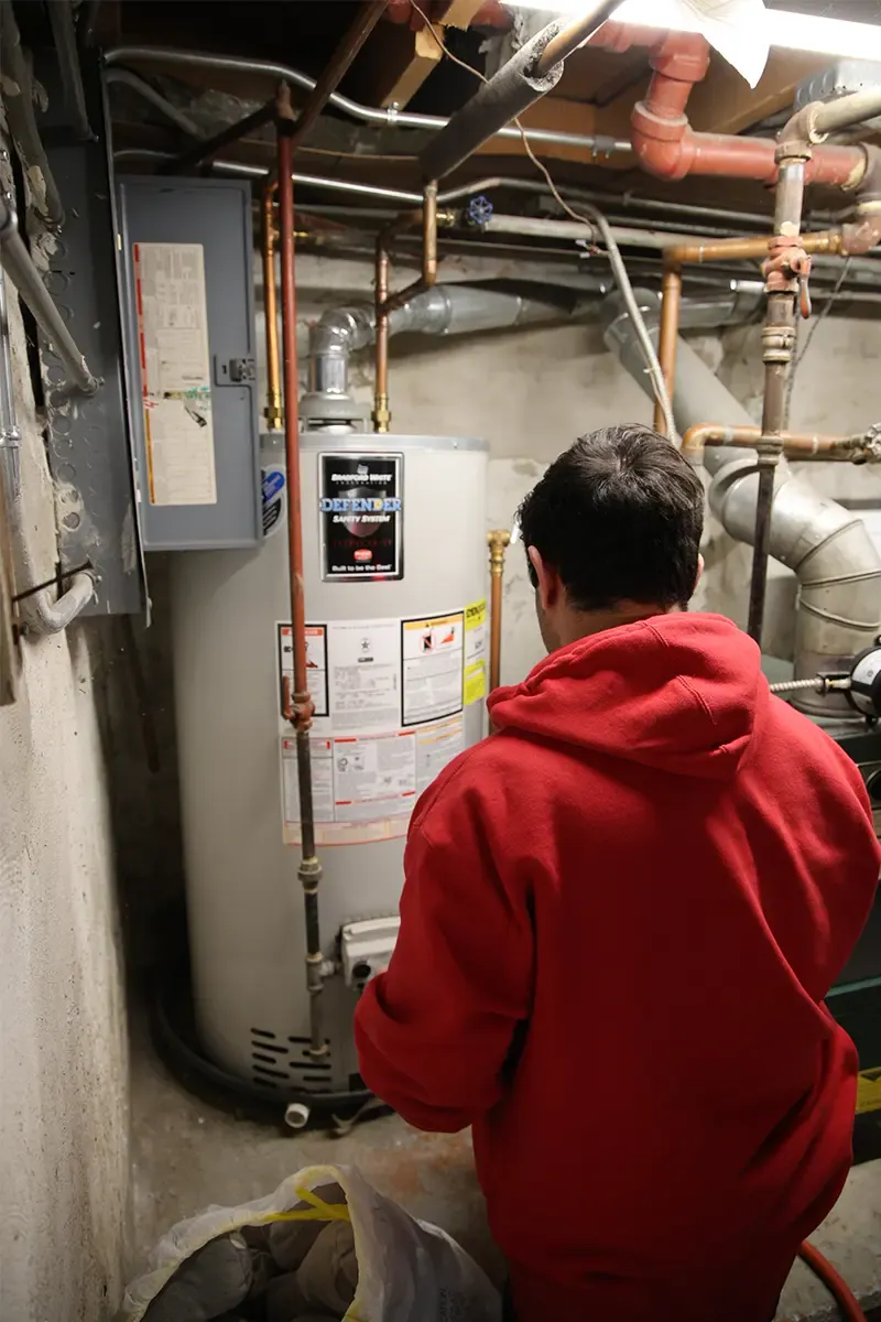 J. Blanton plumber checking a gas water heater during a maintenance visit