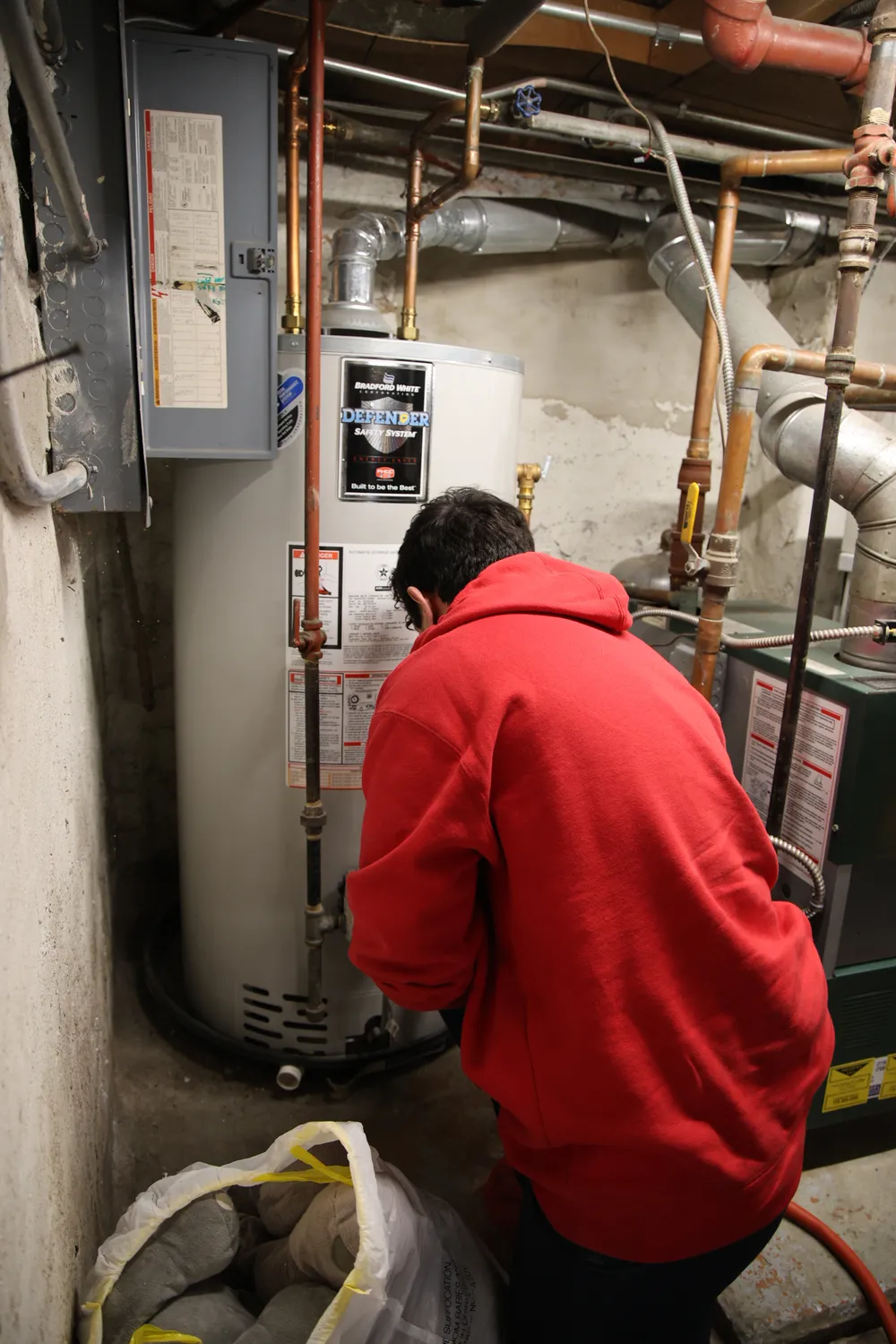 J. Blanton Plumbing technician servicing a Bradford White tank water heater